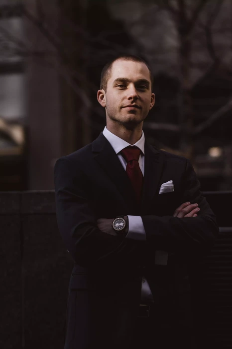 Portrait buste d'un homme d'affaires se tenant les bras croisés sur un fond d'environnement urbain